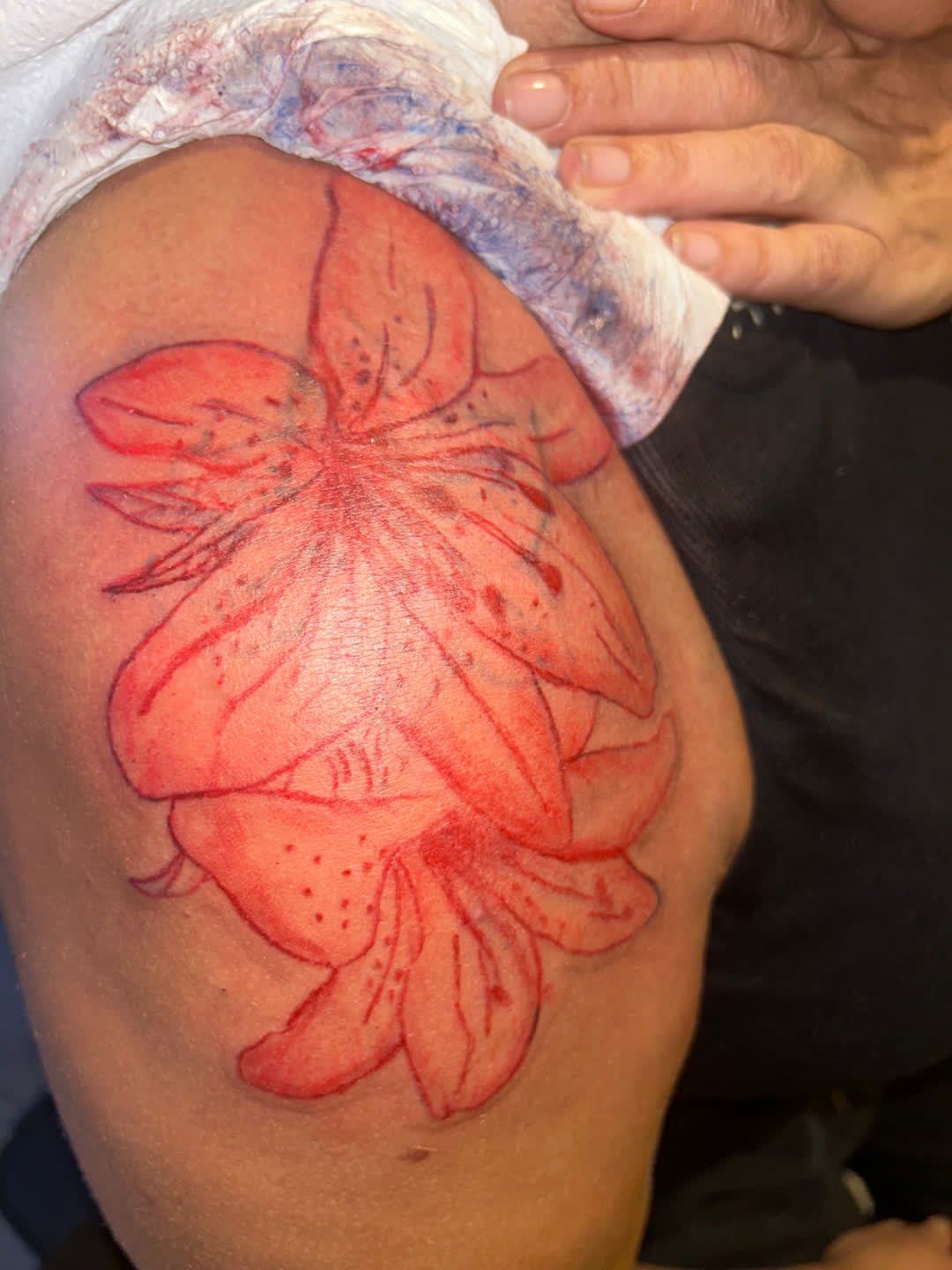 Tatouage floral à l'encre rouge sur l'épaule